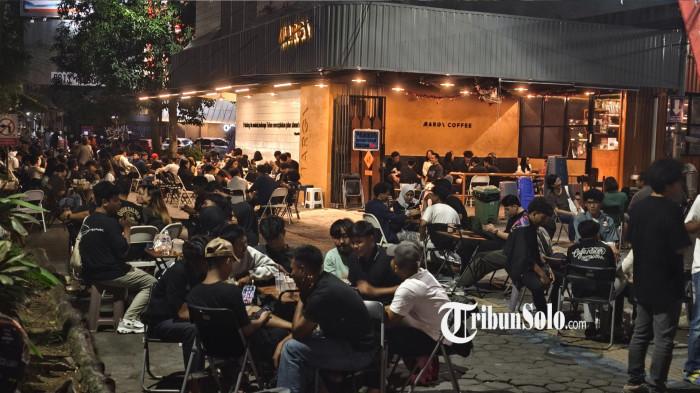 PENUHI CITY WALK - Meja, kursi hingga parkir kendaraan dari pelanggan coffee shop yang memenuhi city walk makin marak, terutama di sekitar Jalan Slamet Riyadi, Solo, Jawa Tengah. Karena dikhawatirkan bisa mengganggu kenyamanan para pejalan kaki, disebut bakal ada pembatasan untuk kendaraan bermotor yang parkir di city walk.