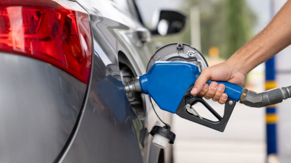 Close shot of a person pumping gas in a car at gas station