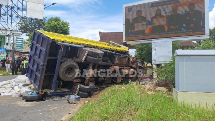 TRUK TERGULING -- Truk bermuatan pupuk terguling, di simpang empat lampu merah Kantor Gubernur Babel, Senin (27/4/2026)