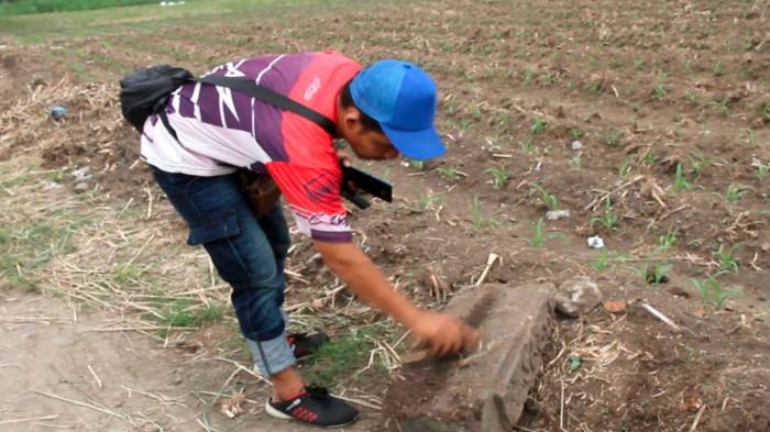 TEMUAN BATU JAMAN MOJOPAHIT - Disporabudpar Kabupaten Nganjuk bersama tim Kotasejuk meninjau lokasi temuan batu andesit berelief angka di area persawahan Desa Klurahan, Kecamatan Ngronggot, Selasa (29/4/2026). Diduga batu ini bagian ambang pintu candi era Majapahit. 
