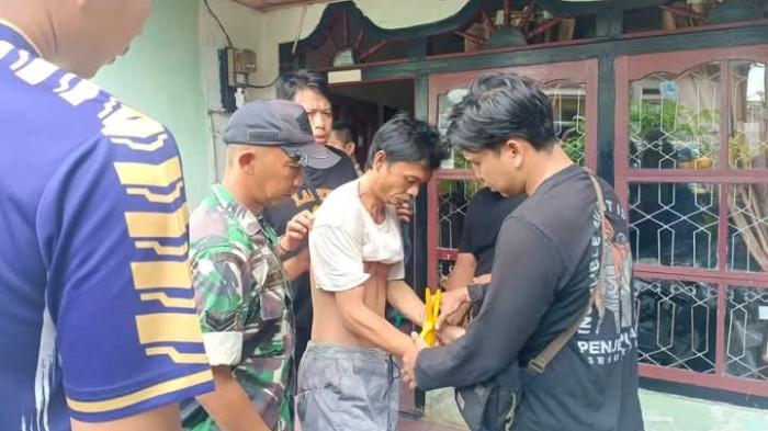 AMANKAN - Terduga pelaku saat diamankan dan hendak dibawa ke Mapolsek Lebong Utara pada Minggu (3/5/2026). Pelaku yang diduga ODGJ ini diamankan usai membacok seorang siswi SD yang merupakan tetangganya sendiri.