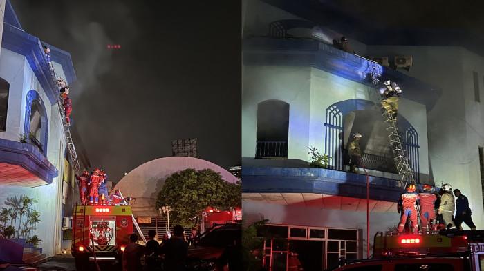 EVAKUASI - Proses evakuasi dua orang yang terjebak di lantai tiga bangunan terbakar di Jalan MT Haryono, samping Java Mall, Peterongan, Semarang Selatan, Kota Semarang, Senin (4/5/2026) malam. Petugas pemadam kebakaran memasang tangga darurat dan memberikan alat pelindung pernapasan di tengah kepulan asap tebal.