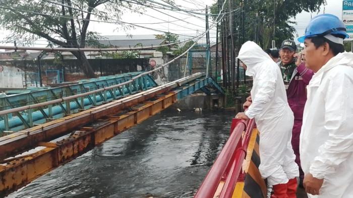 Petugas dan warga tengah memerhatikan kondisi Sungai Kriyan dari jembatan Kesunean, Kelurahan Kasepuhan, Kecamatan Lemahwungkuk, Kota Cirebon, yang menjadi lokasi bocah hanyut paa Senin (4/5/2026) sore.