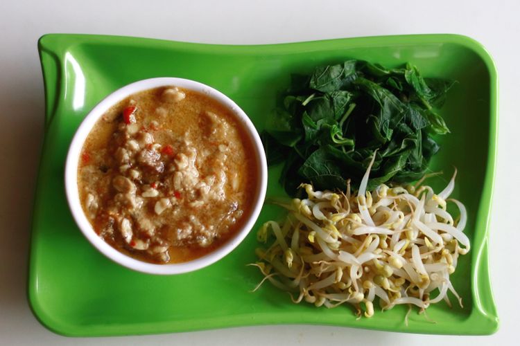 Nasi Pecel Tumpang khas Kediri ini menawarkan cita rasa gurih dan sedikit pedas dari sambal tumpang berbahan tempe fermentasi, disajikan dengan aneka sayuran dan lauk pelengkap yang menggugah selera.