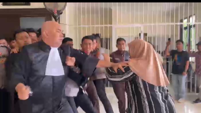 SIDANG PEMBUNUHAN-Terdakwa kasus pembunuhan karyawati koperasi, Risman, digiring keluar ruang sidang PN Pasangkayu dengan pengawalan ketat aparat kepolisian, saat sidang ke-7 dengan agenda pembacaan tuntutan berlangsung ricuh akibat amukan keluarga korban.