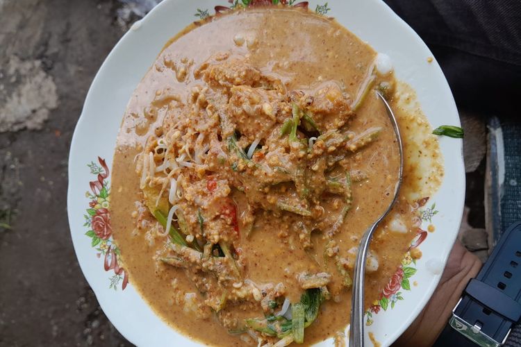 Tajhin Palappa, bubur khas Situbondo yang disajikan dengan bumbu kacang, petis, dan sayuran segar, menjadi menu sarapan favorit dengan cita rasa gurih dan menyegarkan.