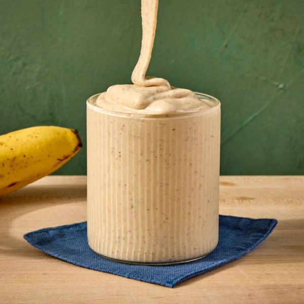 A banana and a creamy smoothie being poured into a glass Credit: Photographer: Jen Causey, Food Stylist: Emily Nabors Hall, Prop Stylist: Lindsey Lower.