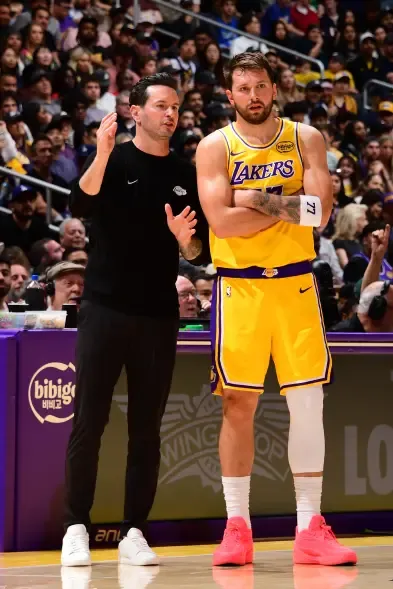 Luka Doncic and head coach JJ Redick of the Los Angeles Lakers talking during a game.