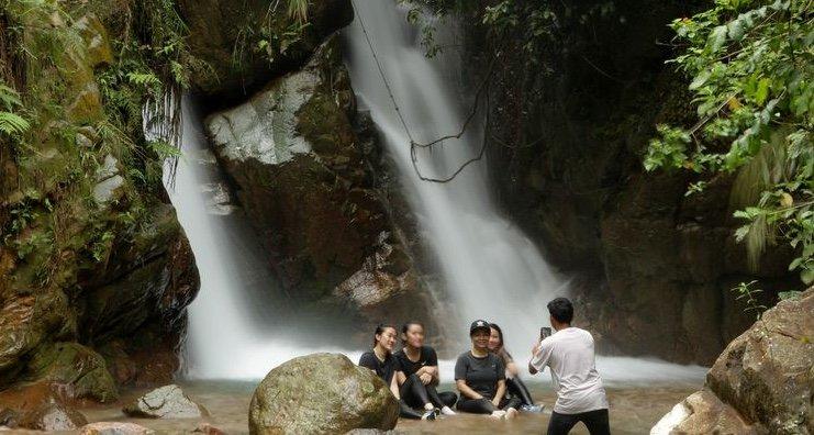 Pengunjung menikmati suasana di Curug Kembar di Kampung Cibereum, Desa Cibadak, Kecamatan Sukamakmur, Kabupaten Bogor, Jawa Barat, Selasa (27/10/2020). Di kawasan ini pengunjung bisa menikmati wisata curug dan trekking menuju 3 destinasi curug yaitu Curug Cibuliar, Curug Kembar, dan Curug Hordeng.
