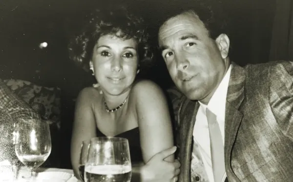Black and white photo of a smiling couple in formal attire.