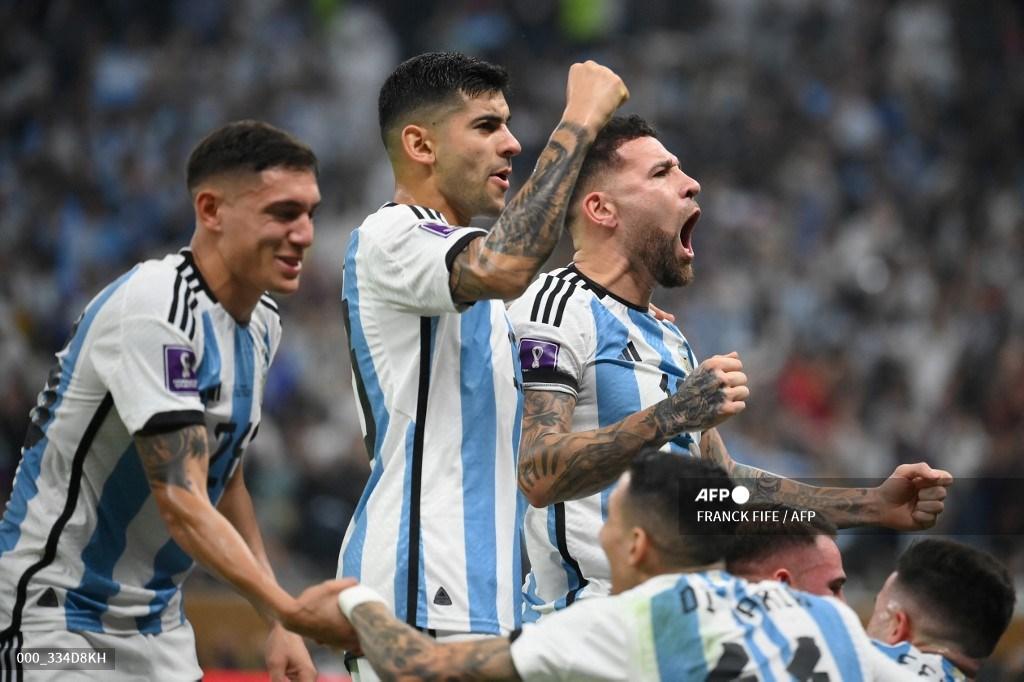 Bek Argentina Nahuel Molina, bek Argentina Cristian Romero dan bek Argentina Nicolas Otamendi merayakan setelah penyerang Argentina Lionel Messi mencetak gol pertama timnya dari titik penalti selama pertandingan final sepak bola Piala Dunia Qatar 2022 antara Argentina dan Prancis di Stadion Lusail di Lusail, utara Doha pada 18 Desember 2022.