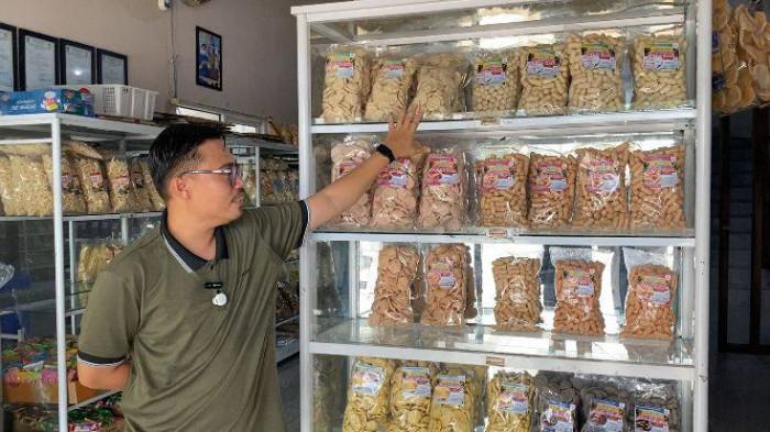 PEMILIK TOKO - Owner Bahek Ewaki, Andreas menunjukkan produk-produknya yakni getas ikan dan getas tinta cumi sebagai produk unggulan, Jumat (8/5/2026).