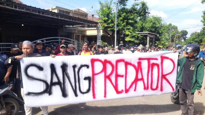 GERUDUK - Warga membawa spanduk dalam aksi demonstrasi di Pondok Pesantren Ndholo Kusumo di Desa Tlogosari, Kecamatan Tlogowungu, Kabupaten Pati, Sabtu (2/5/2026).