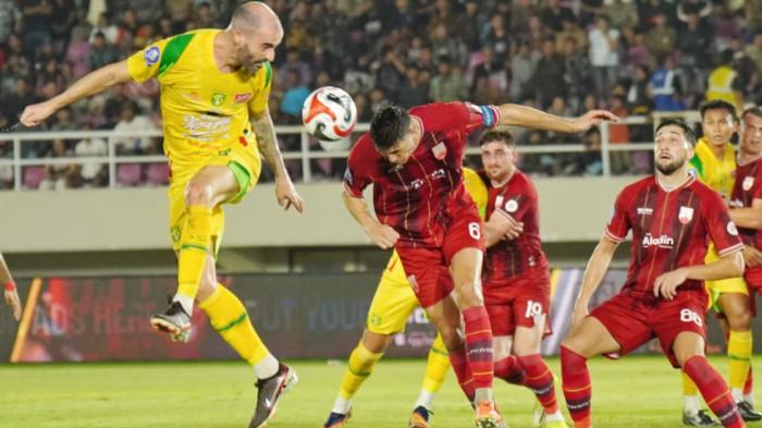 BEREBUT BOLA - Pesepak bola Persebaya, Milos Raickovic berduel udara dengan pesepak bola Persis Solo, Luka Dumancic dalam pertandingan Super League di Stadion Manahan, Solo, Sabtu (9/5/2026) malam. (TRIBUNNEWS/Muhammad Nursina)
