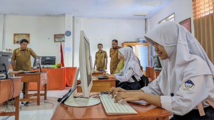 PENERIMAAN SISWA BARU -- Priska Anggraini Bada, siswa SMP 1 Kota Gorontalo saat mengoperasikan komputer di SMA Negeri 3 Gorontalo. (TribunGorontalo.com/Herjianto Tangahu)