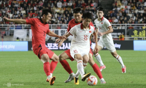 Forward Nguyen Dinh Bac (number 15) shields defenders Lee Ki-je (number 2) and Kim Min-jae during Vietnams 0-6 friendly loss to South Korea at the Suwon World Cup Stadium on Oct. 17, 2023. Photo by Read/Nghia Hung