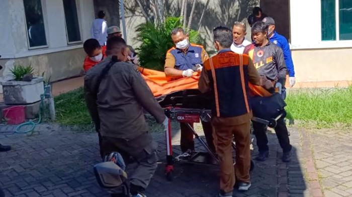 KORBAN - Saat petugas Polisi dan BPBD evakuasi jenazah DM (48) satpam perumahan ditemukan tewas dengan 6 luka tusuk di sebuah rumah kosong dekat pos tempatnya berjaga kawasan Jalan Sukomanunggal Jaya, Kota Surabaya, Jawa Timur, Senin (11/5/2026). Lalu jenazah diangkut ambulan untuk dibawa ke RS Bhayangkara Surabaya