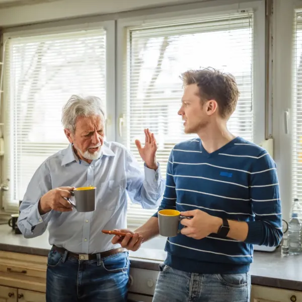 young man trying to share facts with his dad who is uncomfortable changing long-held beliefs