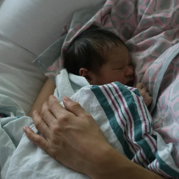 mom holding her newborn baby in the hospital