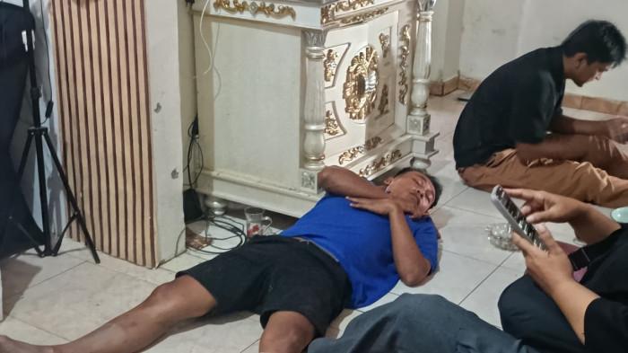 KEMBALI KE RUMAH -- Potret Isten Laiya (pria berbaju biru) berbaring di lantai. Isten Laiya sempat dikabarkan melompat di jembatan Talumolo II, Kota Gorontalo.
