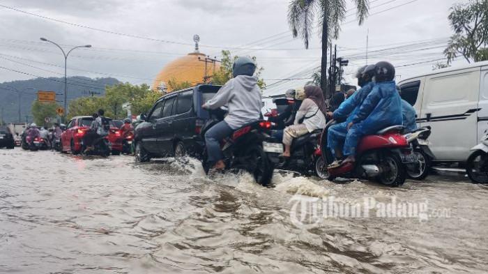 BANJIR PADANG - Banjir merendam Jalan Raya Lubuk Begalung di depan Kampus UPI YPTK Padang, Rabu (13/5/2026). Akibat genangan air tersebut, kemacetan panjang terjadi saat jam pulang kerja dan sejumlah sepeda motor pengendara mengalami mogok.