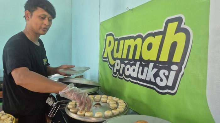 BARU MATANG - Pemilik Bakpia SMS Slamet Prihatin mengambil bakpia yang baru matang dari loyang, di rumah produksi Bakpia SMS di Jalan Pramuka di Desa Karangklesem, Kecamatan Pekuncen, Kabupaten Banyumas, Jawa Tengah, Sabtu (2/5/2026).