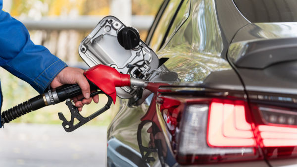 Close of man filling a car's fuel tank on a gasoline station forecourt