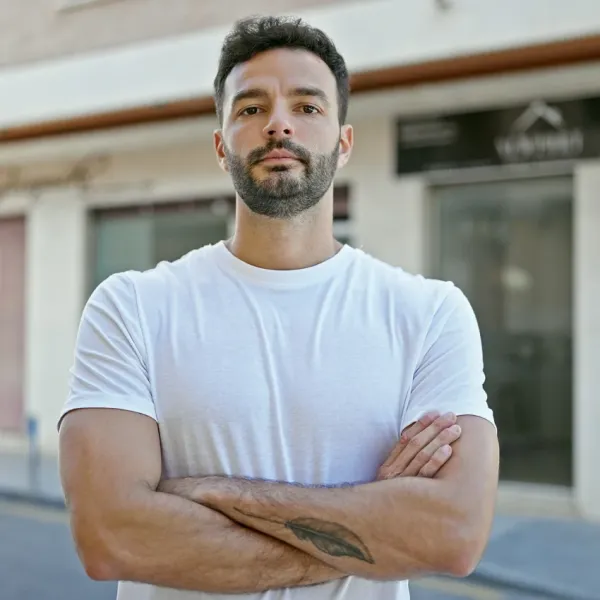 man standing with arms crossed outside