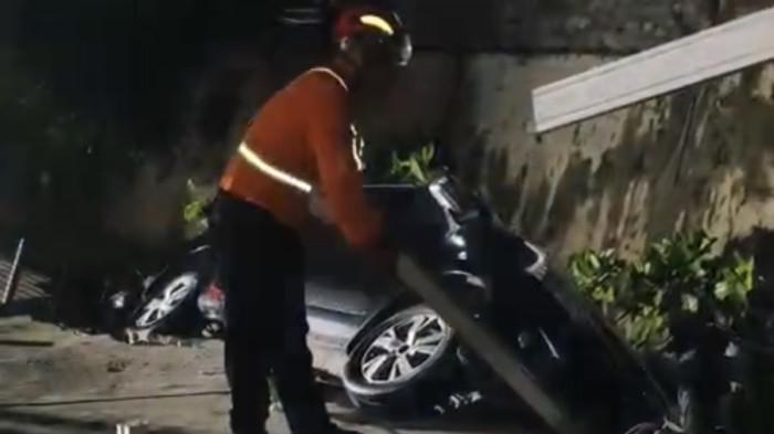 EVAKUASI - Anggota Basarnas Semarang bersama Damkar Kota Semarang mengevakuasi sebuah mobil yang nyaris jatuh ke Sungai Bringin di Jalan Mega Raya, Kelurahan Bringin, Kecamatan Ngaliyan, Kota Semarang, Jumat (15/5/2026) malam. Mobil tersebut terancam tercebur setelah talud sungai ambrol akibat hujan lebat yang mengguyur kawasan itu sejak petang.