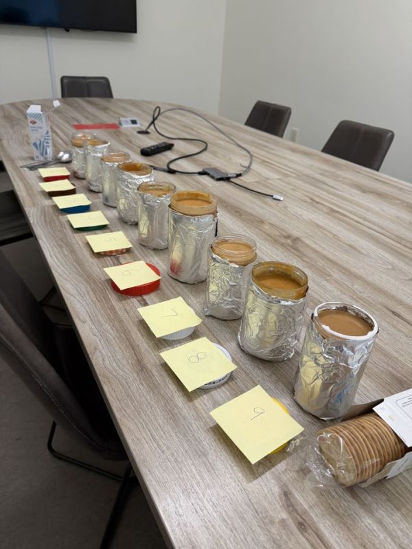 A table with cans of food labeled with sticky notes arranged in a line for a tasting or experimental setup Credit: Jessica BallCredit: EatingWell.