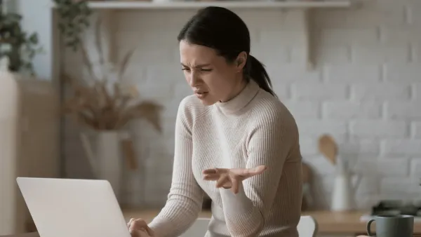 Woman who needs a break looks at her computer with frustration 