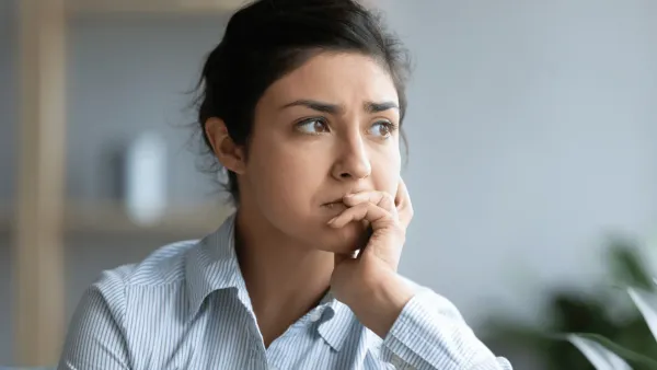Woman who needs a break looks out the window worriedly 