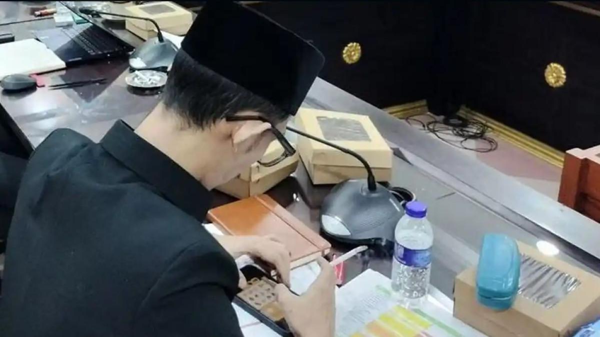 RAPAT DPRD VIRAL - Anggota Komisi D DPRD Jember Achmad Syahri Assidiqi menjadi sorotan usai videonya bermain game sambil memegang rokok saat rapat dengar pendapat beredar di media sosial.