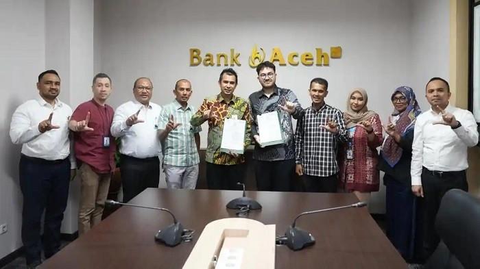 FOTO BERSAMA - Direktur Dana dan Jasa Bank Aceh, M Hendra Supardi serta Direktur Pengembangan Produk dan Ekosistem PosSaku, Muharrir Hasbi, foto bersama dengan jajaran usai penandatanganan naskah kerja sama di Kantor Pusat Bank Aceh, Banda Aceh, pada Senin (18/5/2026).