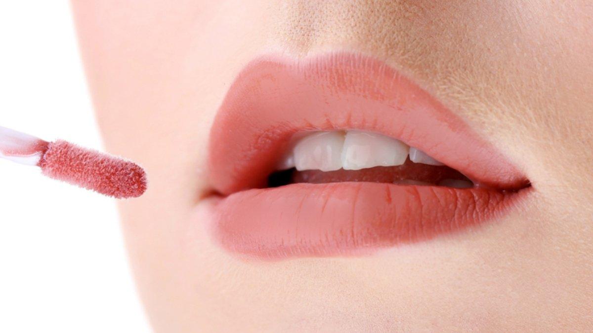 Ilustrasi wanita mengaplikasikan lipstik.