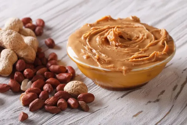 Tasty peanut butter in a bowl close up on the table. horizontal