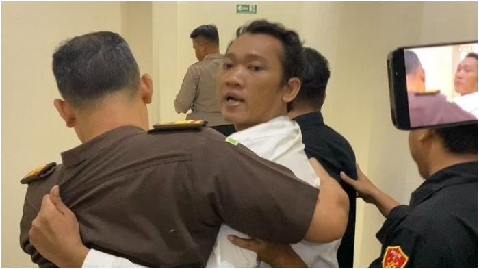 PEMBUNUHAN KEJI - Ririn Rifanto, terdakwa pembunuhan satu keluarga saat berontak ketika diseret petugas meninggalkan ruang sidang di Pengadilan Negeri Indramayu, Rabu (29/4/2026) malam.