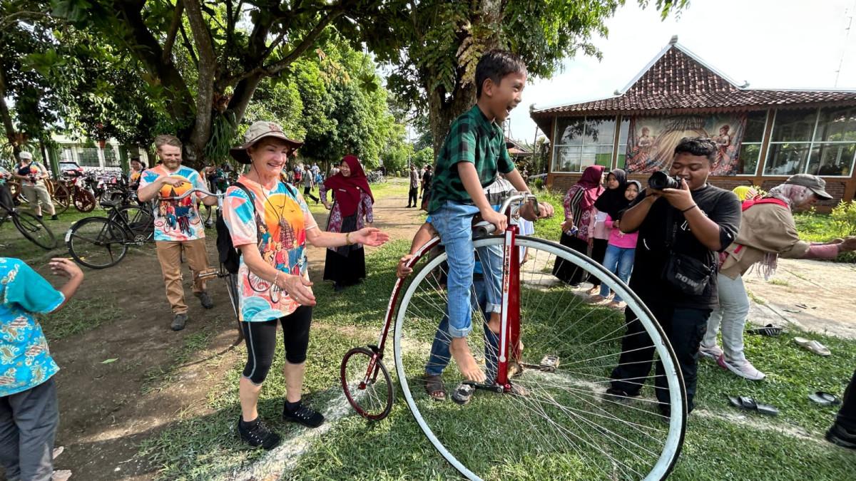 KLICFEST 2026 - Peserta berinteraksi dengan anak-anak menggunakan sepeda klasik Penny Farthing saat mengikuti agenda “Social Culture Ride”, Kamis (21/5/2026).