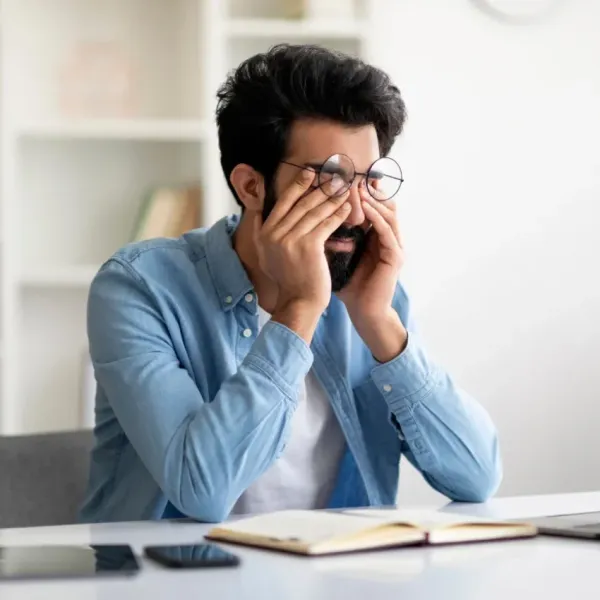 man who has twitchy eyes from being stressed at work