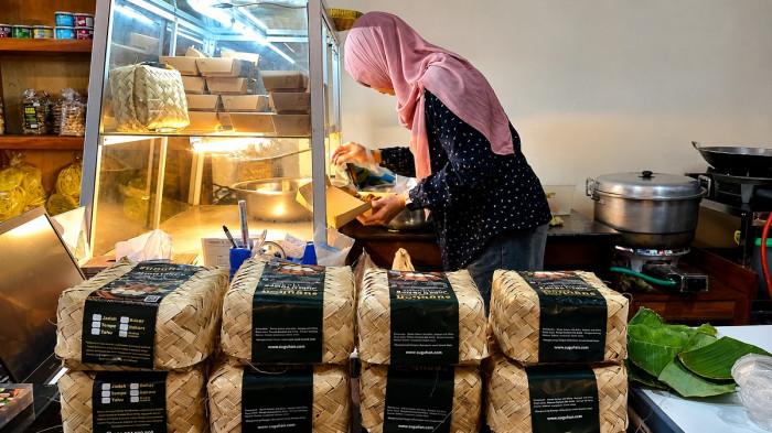 Karyawan menyiapkan pesanan jadah tempe di industri rumahan Suguhan by Mbah Carik