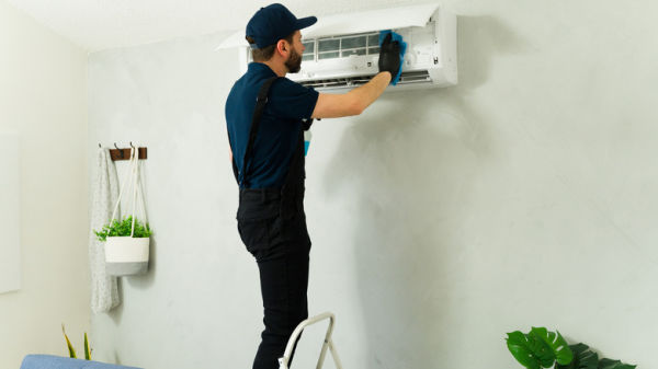 Man installing mini split indoors