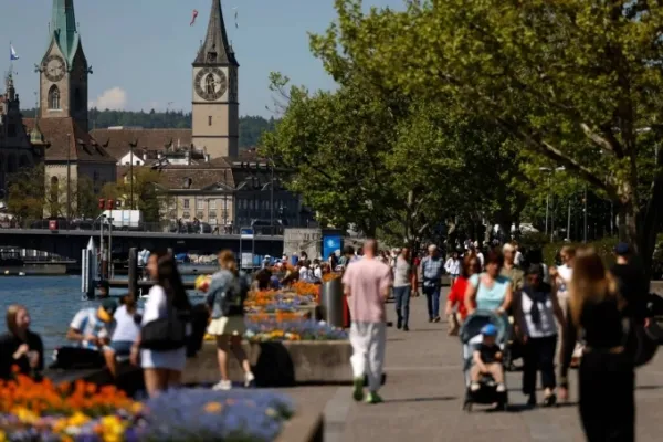People walk along the shore of lake on a warm spring afternoon in Zurich, Switzerland April 30, 2025. Photo by Reuters.