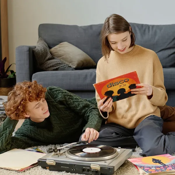 two people looking at and playing vinyl records