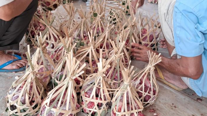 WADAH UNIK - Warga di Kampung Cimuruy RW 01, Desa Mekarmulya Kecamatan Situraja, Kabupaten Sumedang, memilih rinjing anyaman bambu dan daun jati saat membagikan daging kurban pada Hari Raya Idul Adha 1447 Hijriah, Rabu (27/5/2026).