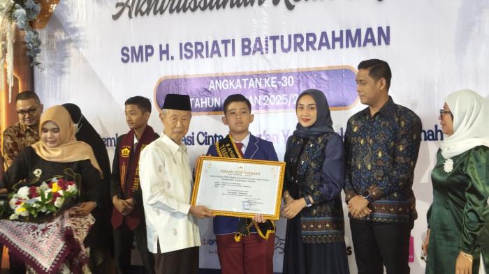 BERI PENGHARGAAN - Ketua Umum Yayasan Pusat Kajian dan Pengembangan Islam (YPKPI), KH Ahmad Daroji memberikan penghargaan bagi siswa SD Hj. Isriati Baiturrahman 1, M Arkananta Abdusalam yang berhasil meraih peringkat pertama Tes Kompetensi Akademik (TKA) tingkat nasional tahun 2026, Minggu (31/5/2026).