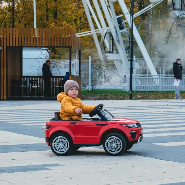 child driving a toy car