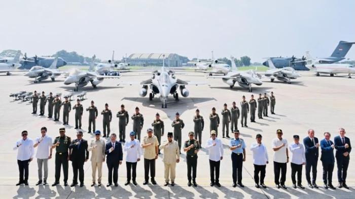 PRABOWO DAN ALUTSITA - Presiden RI Prabowo Subianto bersama kabinet, termasuk Menteri Keuangan, berfoto bersama di depan sejumlah pesawat militer usai penyerahan 6 Jet Rafale dan Radar GCI ke TNI AU di Lanud Halim Perdanakusuma, Jakarta Timur, Senin (18/5/2026). Pada momen ini, Menkeu Purbaya memastikan kesiapan anggaran pertahanan jangka panjang tahun 2027 tanpa mengganggu stabilitas subsidi publik.