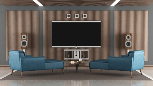 A home theater room with large TV, hi-fi loudspeakers, and two green chaise longues