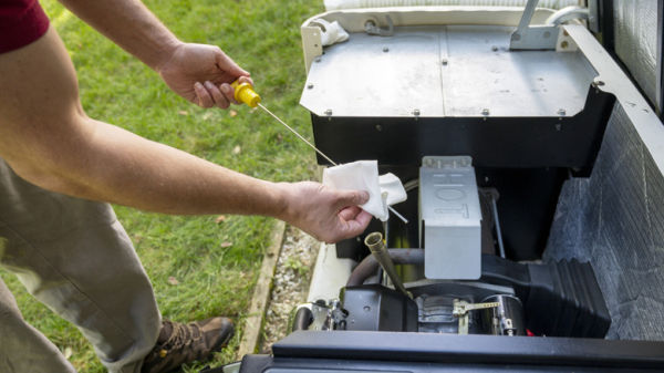 A man checking the oil on a standby generator
