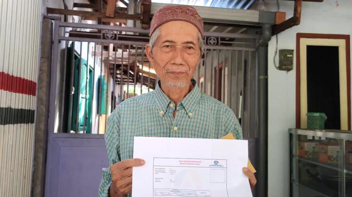 PROYEK STRATEGIS - Mohammad Sirozi (78) pemilik rumah usaha dan lahan di Jalan Raya Raden Wijaya Desa Jotangan, Kecamatan Mojosari, Kabupaten Mojokerto, Jawa Timur, terdampak pemindahan pusat ibu kota Mojokerto, Rabu (3/6/2026). Ia menunjukkan surat appraisal yang dinilai terlalu rendah.